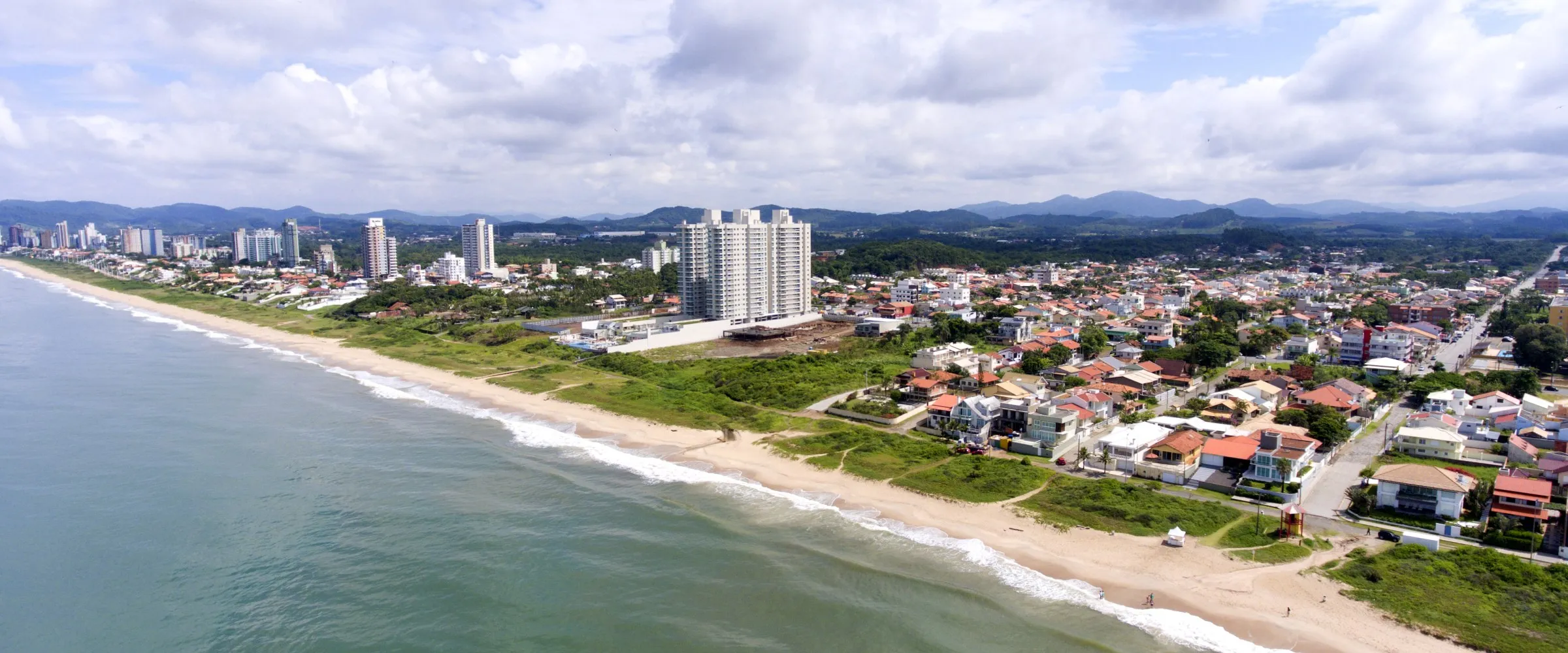 Vista aérea da orla de Balneário Piçarras, com casas e prédios junto à praia